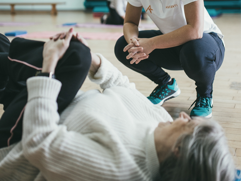 Physio watches patient try a back roll