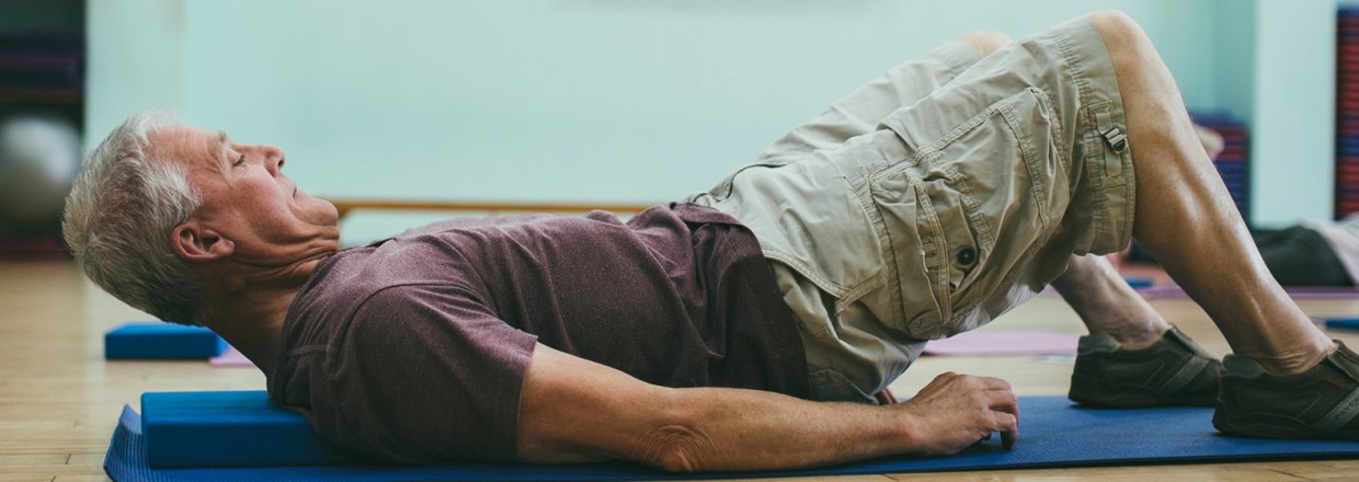 Man lying on floor doing back exercises